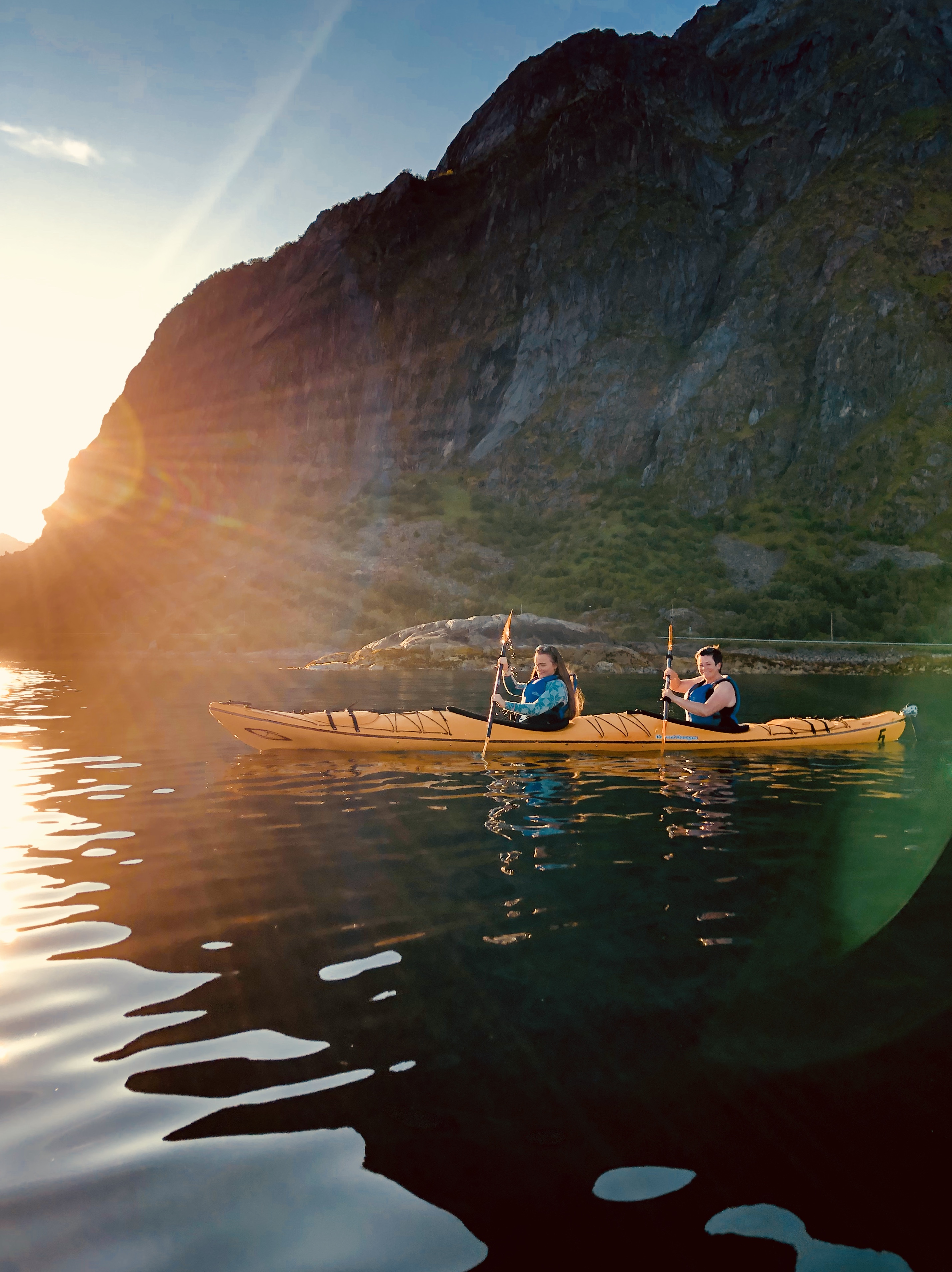 A double kayak along the coast of Lofoten in midnight sun